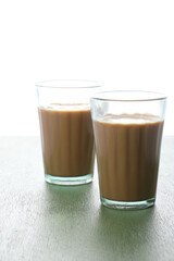 Indian Chai or Indian tea served in a traditional tea glass with snacks 