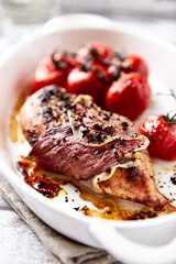 Baked chicken breasts with ham, cherry tomatoes. Close up.