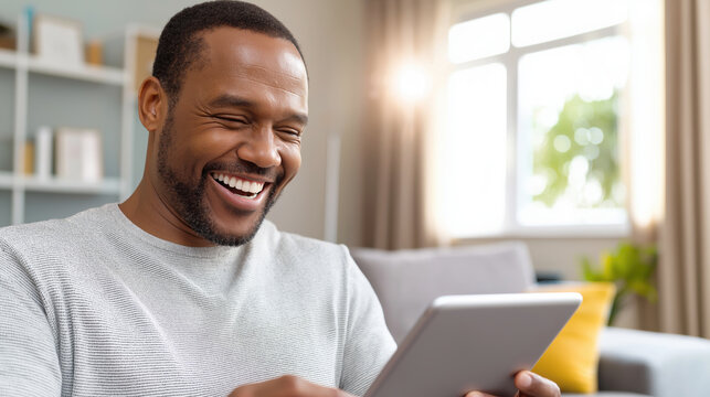 Smiling man enjoying tablet in bright living room setting