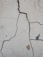Fototapeta premium Cracked and weathered cement surface wall with peeling paint and stains, wall, grungy