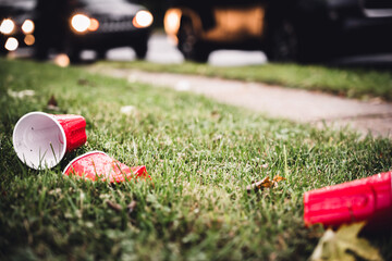 Crushed and discarded red plastic cups after a college party