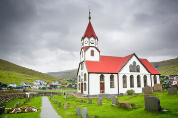 Distinctive red-roofed church in the town of Sandavágur in the Faroe Islands