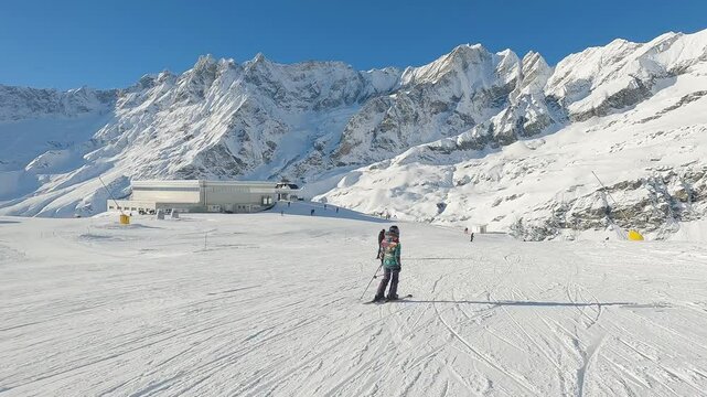 Female skier ski in Cervinia ski resort with alps mountain range view