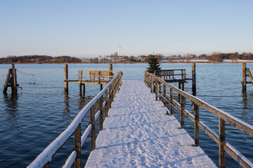 Fototapeta premium Schnee bedeckter Steg an Schlei in Sieseby im Winter.