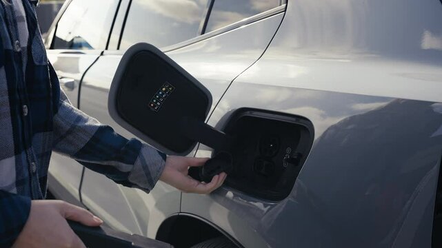 Person unplugs the charging cable from car port and puts protective covers on 