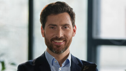 Close-up caucasian bearded man looking side and turning gaze to camera smiling successful mature businessman entrepreneur leader ceo employer professional manager posing indoors male business portrait