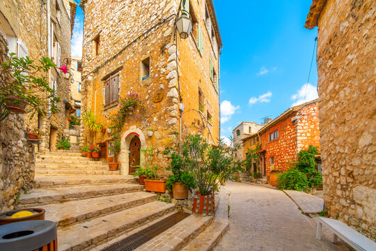 Fototapeta Colorful medieval stone buildings along the Grand Rue main street through the hilltop village of Tourrettes-sur-Loup, France, in the Alpes-Maritimes region of Southern France.