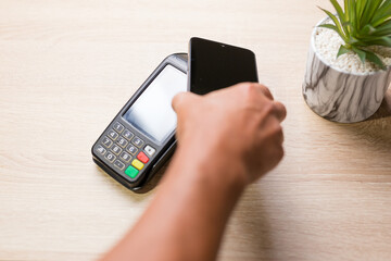 Customer paying with nfc technology on pos terminal