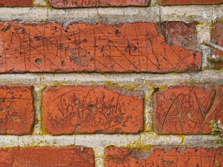 Wall background, writing and scratch on brick of building in city for texture, pattern and exterior...