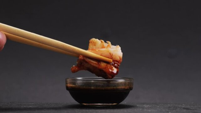 Shrimp sushi or Japanese ebi sushi set on black plate with wasabi in flash lighting.