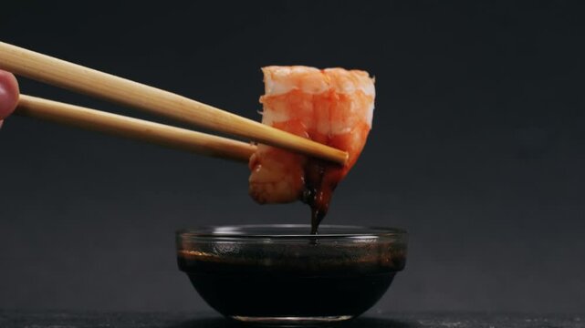 Shrimp sushi or Japanese ebi sushi set on black plate with wasabi in flash lighting.