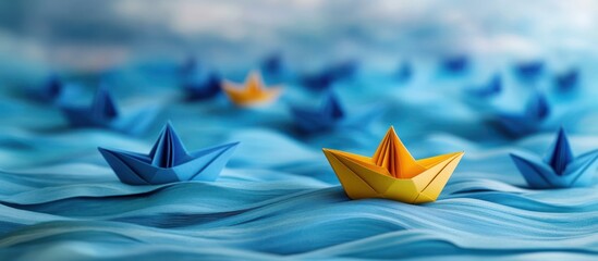 One yellow paper boat stands out among many blue paper boats floating on a blue wavy surface.