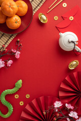 Elegant vertical arrangement of traditional Chinese New Year items, including oranges, tea set, and symbolic decorations on a vibrant red background
