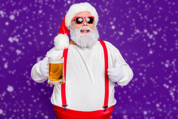Close-up portrait of his he nice cheery glad cheerful satosfied bearded thick fat Santa drinking beer showing thumbup isolated over bright vivid shine vibrant violet lilac background