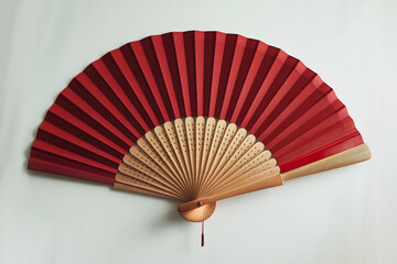 Red fan on white background with wooden handle, blending traditional, modern aesthetics