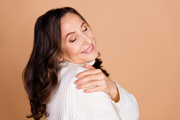 Photo of pretty cute lovely woman wear white trendy clothes hug herself isolated on beige color background