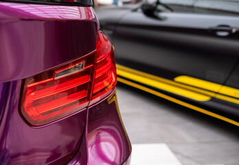 Rear light of violet sport car close up, car motor show