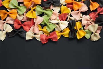 Colorful Italian farfalle pasta on a black background - Copy space