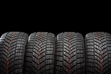 Four winter tires standing on black background