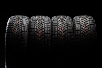 Four winter tires standing on black background
