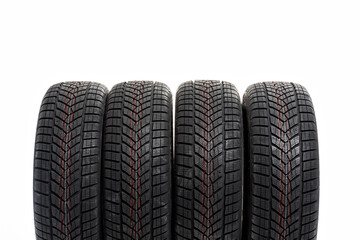 Fototapeta premium Four winter tires standing on white background in a row