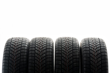 Four winter tires standing on white background in studio shot © Maria Vitkovska