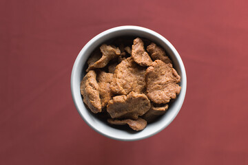 Overhead view of kuli-kuli on a white plate, top view of nigerian groundnut cakes on a plate, fresh homemade nigerian kulikuli on a ceramic plate
