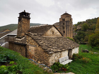 Casa rural con tejado de piedra y con iglesia rom&aacute;nica en Huesca