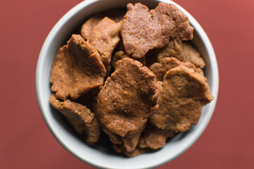 Overhead view of kuli-kuli on a white plate, top view of nigerian groundnut cakes on a plate, fresh homemade nigerian kulikuli on a ceramic plate