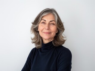 Obraz premium Woman with gray hair is smiling and wearing a blue shirt. She is posing for a photo