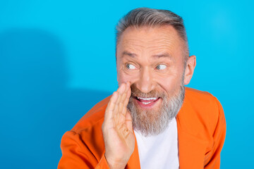 Photo of trendy eccentric man whisper empty space wear orange suit isolated on blue color background