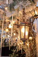 street decoration for christmas. tree decorated with lantern, christmas lights and bulbs. evening and holiday atmosphere.