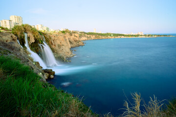 Scenic view of Duden Waterfall in Antalya, Turkey, cascading from cliffs into the Mediterranean Sea...