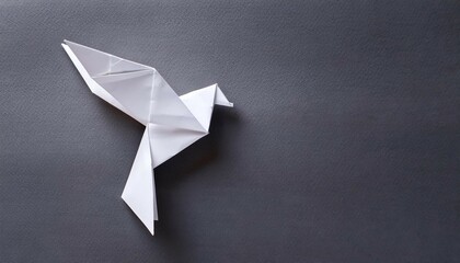 minimalist white origami dove on gray background © Matteo