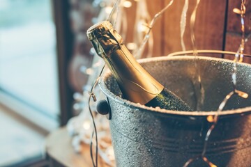 Champagne bottle in ice bucket with festive lights