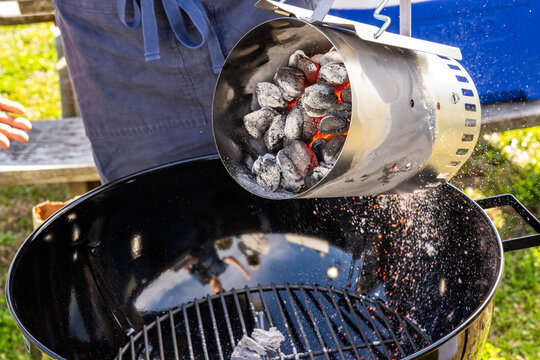 Charcoal being poured into a grill 