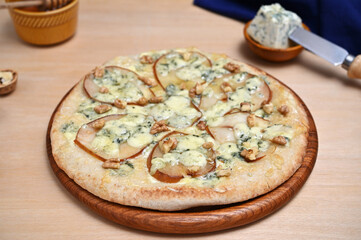 delicious pizza with pear slices, gorgonzola and walnuts close-up