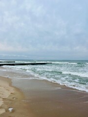 cloudy grey seascape, waved sea horizon, windy at the sea, empty beach