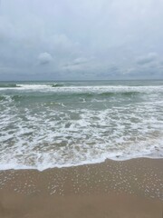 cloudy grey seascape, waved sea horizon, windy at the sea, empty beach