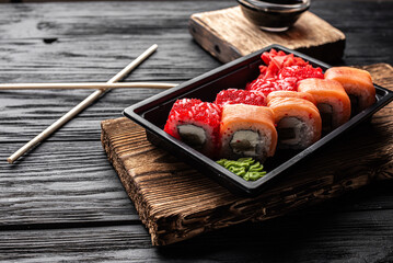 Assorted Sushi Rolls on Dark Plate with Condiments