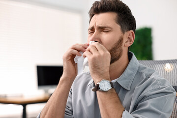 Sick man with runny nose in office