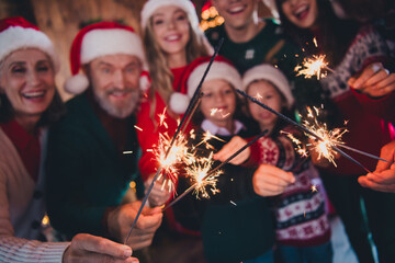 Cropped portrait of friendly peaceful family hold sparkler sticks gather celebrate new year xmas flat indoors