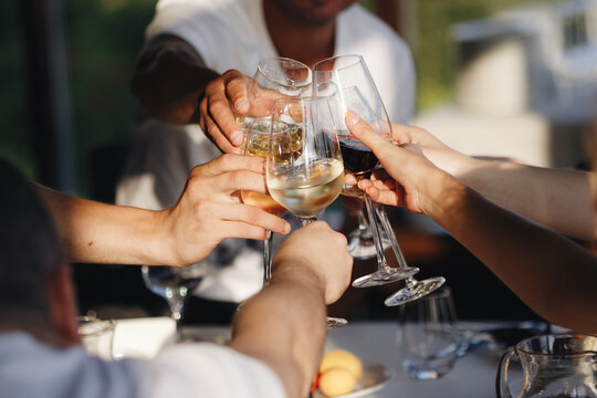 Celebrating with glasses of alcohol in hands. Happy friends having good time.