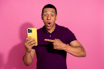 Photo portrait of attractive young man hold device point amazed dressed stylish violet clothes...