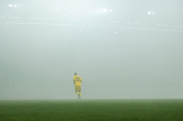 Footballer on the field during fog at the stadium