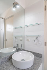 habitacion de baño con lavabo moderno espejos y acabados modenos color blanco 