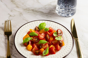 Salad with halves of red and yellow tomatoes cherry with basil