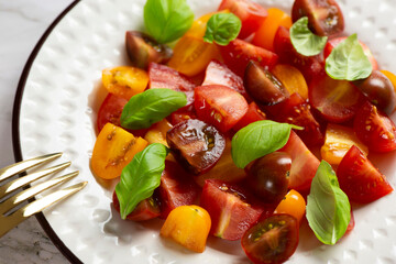 Salad with halves of red and yellow tomatoes cherry with basil