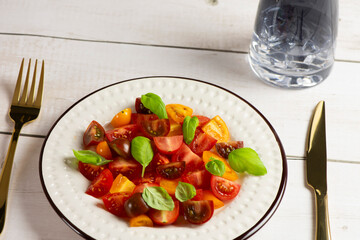 Salad with halves of red and yellow tomatoes cherry with basil