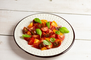 Salad with halves of red and yellow tomatoes cherry with basil